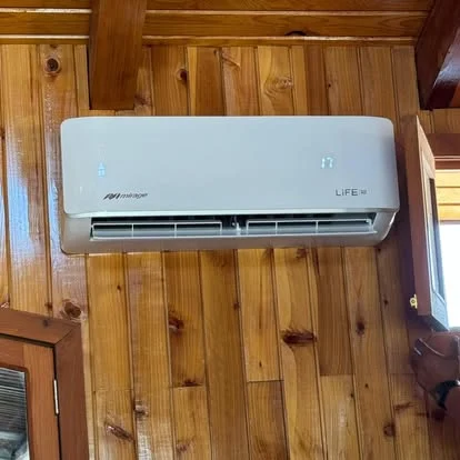 Minisplit instalado por Rino en un muro con acabado de madera.